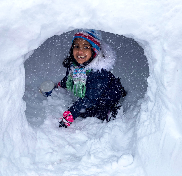 Girl playing in a snow fort
