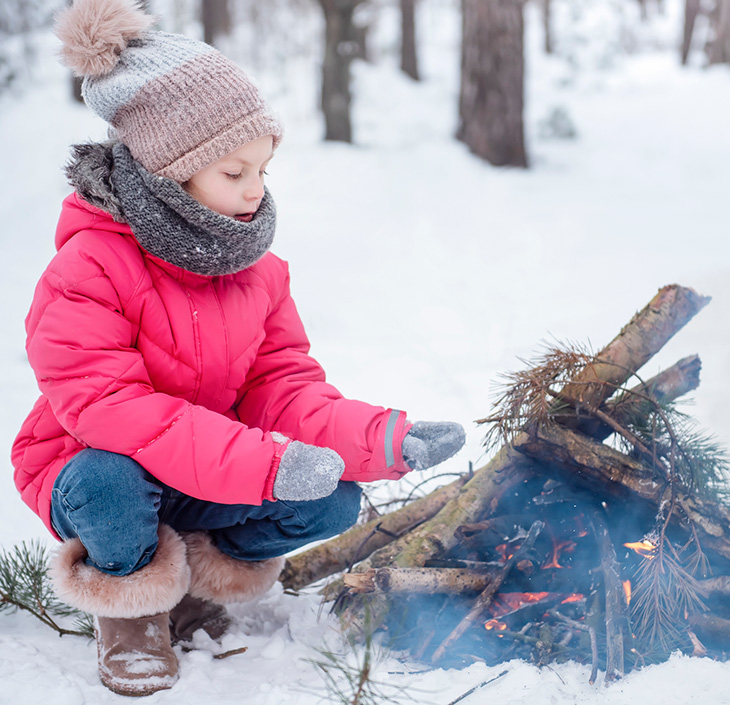 Girl building a winter campfire