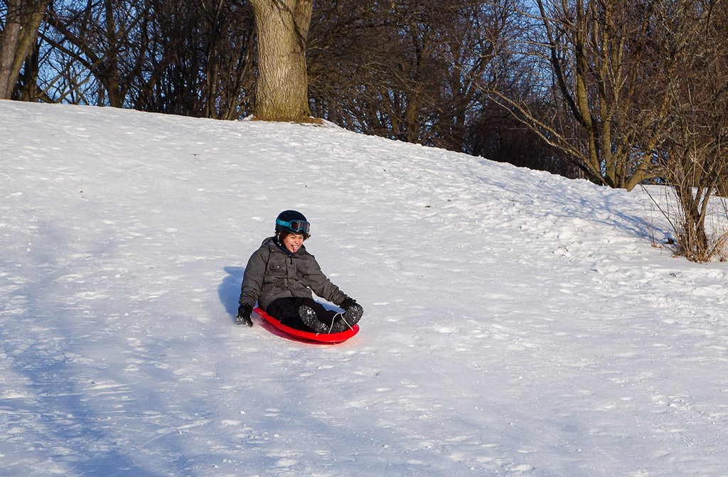 Boy sledding down a hill
